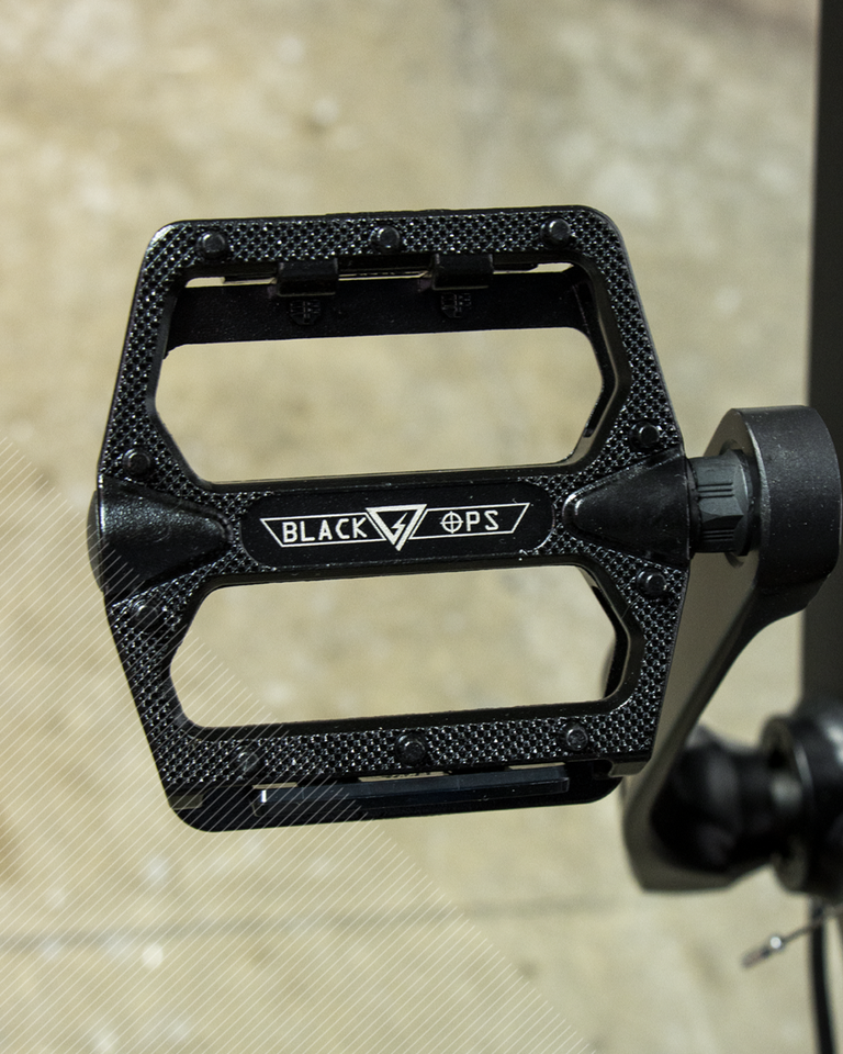 An up close black, Black Ops brand pedal on the bike 